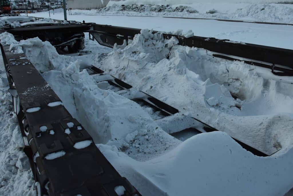 Det bygger seg på store mengder snø og is på vognene underveis som må fjernes før det kan lastes opp på nytt.