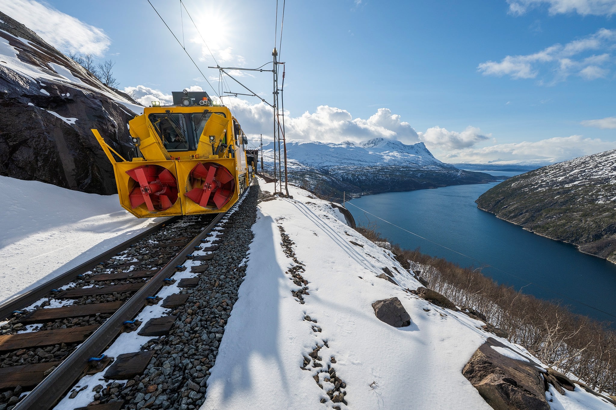 Brøytemaskin på Ofotbanen med vakker fjellnatur i bakgrnnen.