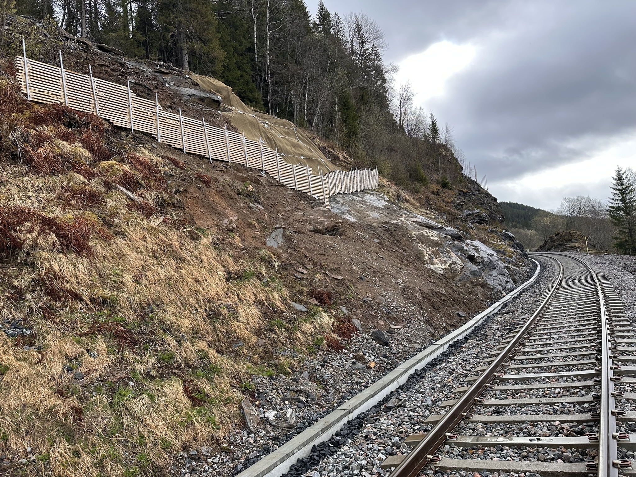 Sideterrenget sikres med bolting, matter og støttemurer. Slike tiltak gjennomføres en rekke steder langs Nordlandsbanen.