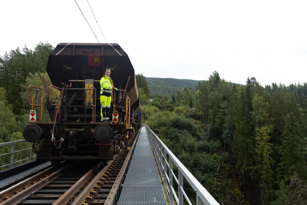 Kvinne i verneklær på baksiden av en pukkvogn