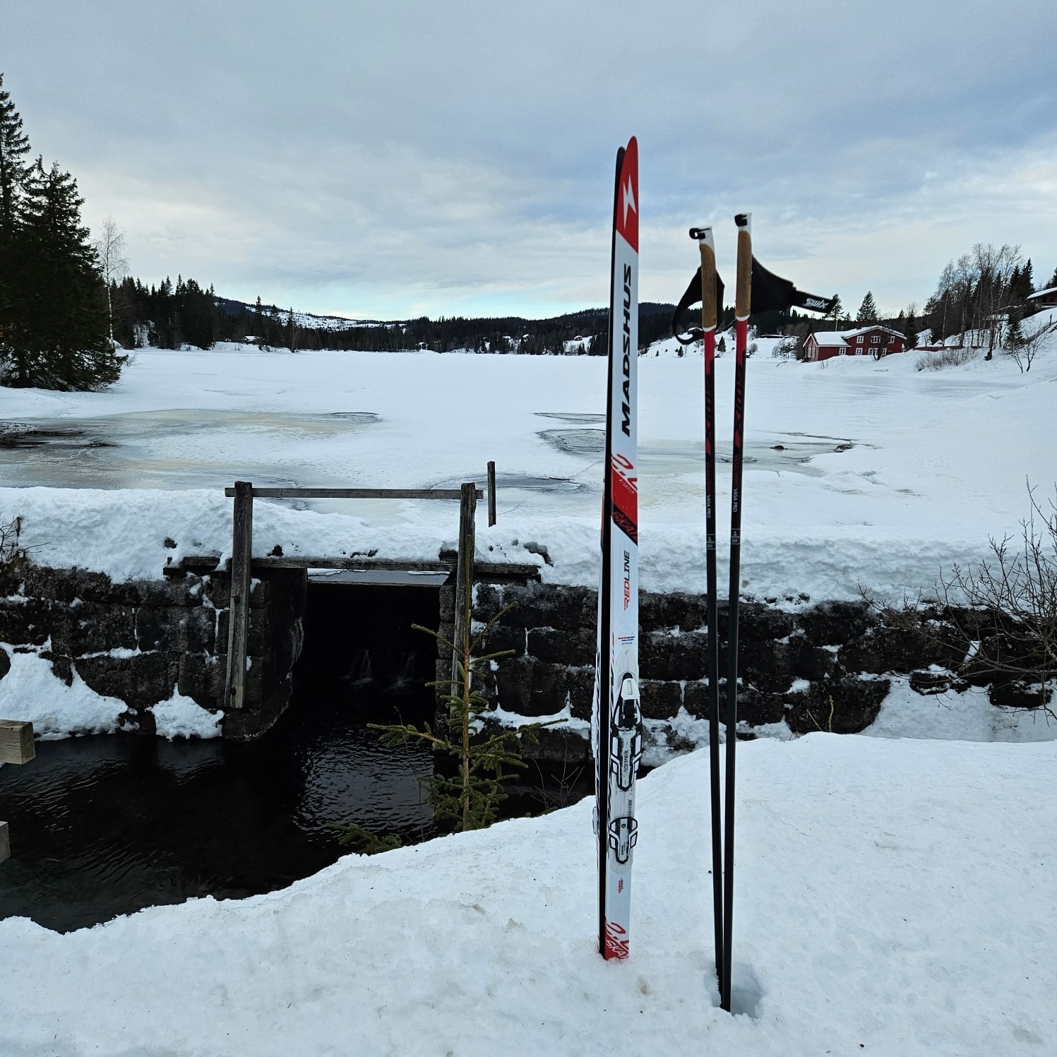 Bilde av ski og staver ved siden av en bekk.