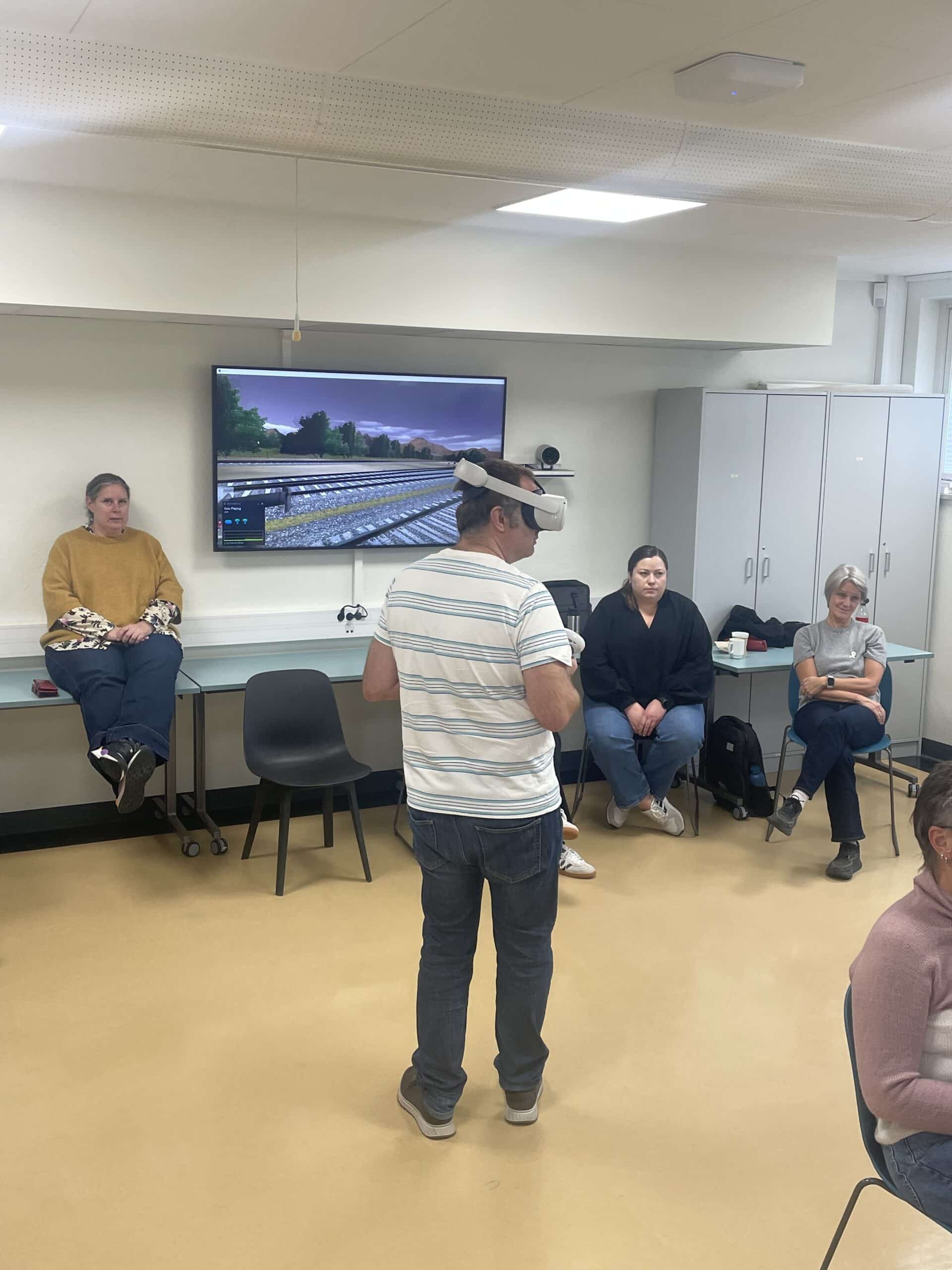 Håkon demonstrerer vår VR for andre studenter.