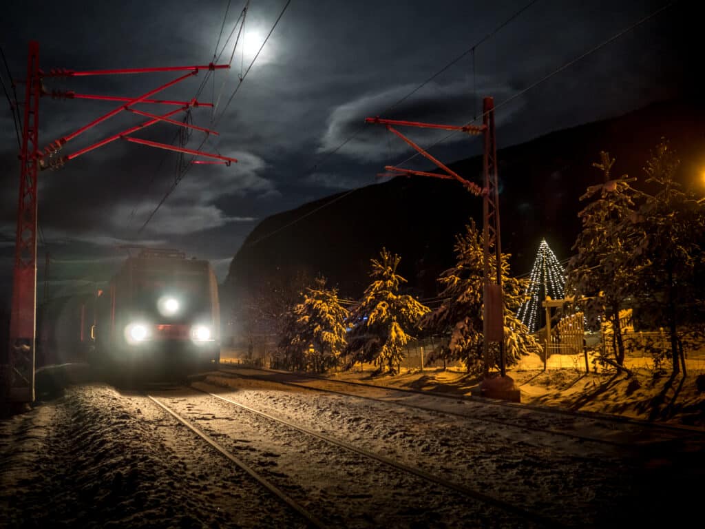 Stemningsfullt bilde av tog og juletre ved sporet
