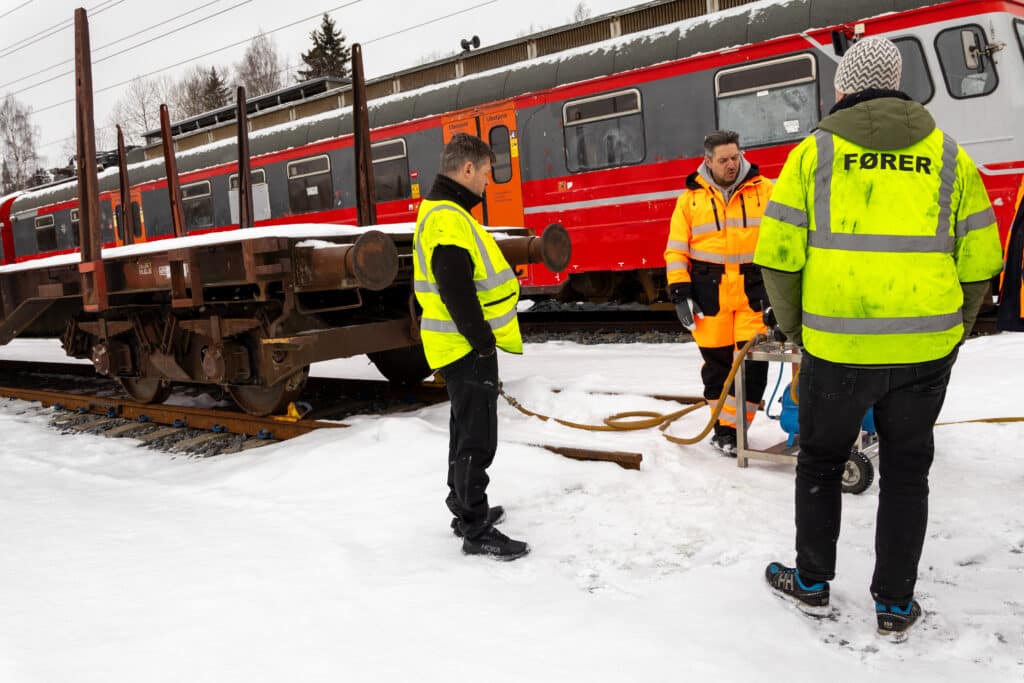 Bilde av menn i verneklær ved tog og vogn